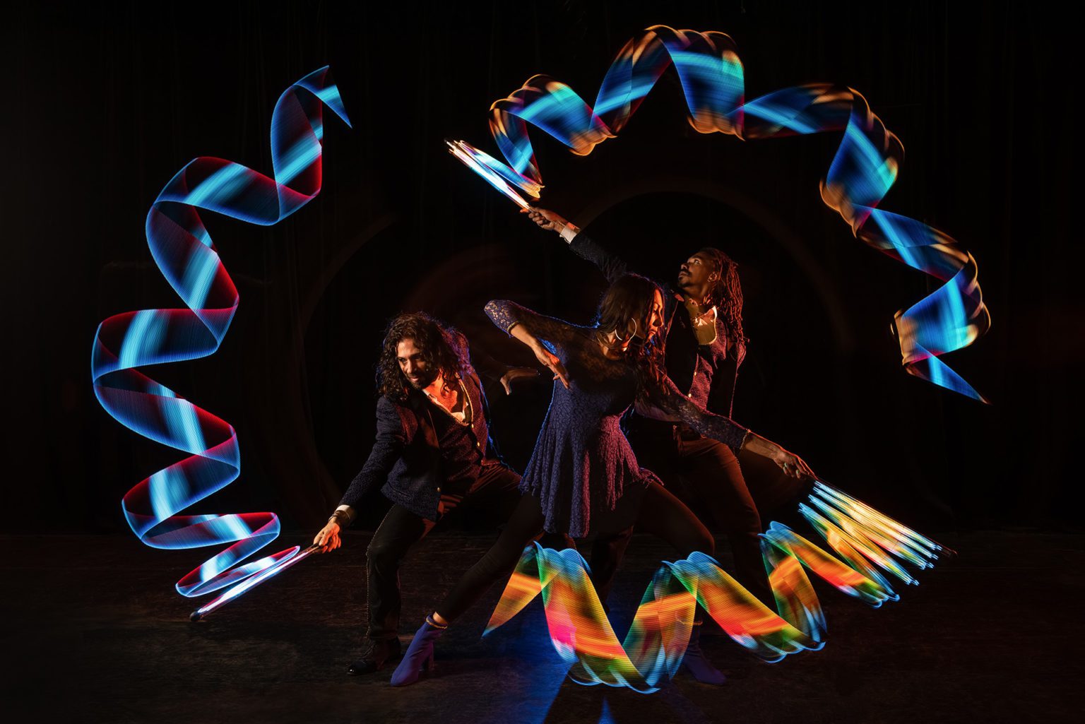 3 artiste dessinant avec la lumiere LED
